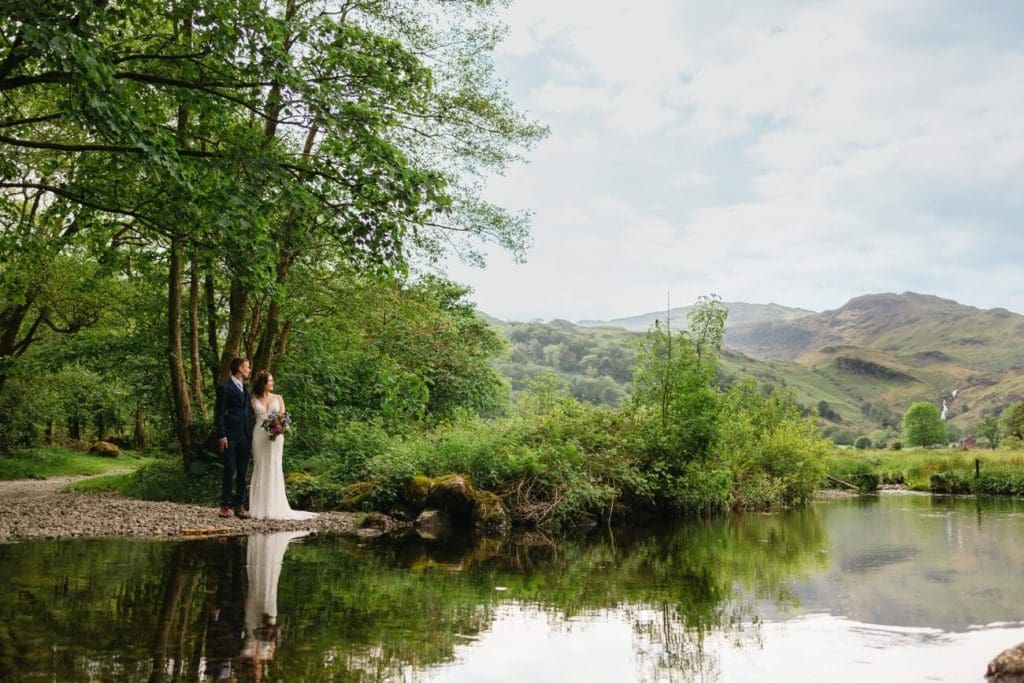 Wedding couple stood next to a pond at Lancrigg Hotel